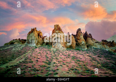 Formazioni rocciose con red Brome erba e nuvole in Leslie Gultch. Malhuer County, Oregon Foto Stock