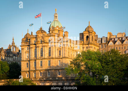 Bandiere di volare al di sopra della Bank of Scotland edificio al tramonto, Edimburgo, Scozia Foto Stock