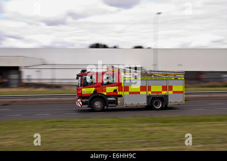 Un motore antincendio Scottish Fire and Rescue Service che accelera lungo la Kingsway West Dual Carriage rispondendo a una chiamata del 999 a Dundee, Scozia Foto Stock