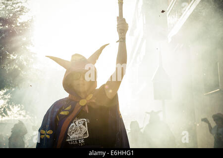 Sitges, Spagna. 23 Ago, 2014. Un membro di "Ball de Diables' mette fuori i suoi fuochi d'artificio al tramonto durante la " Festa Major de Sitges' © Matthias Oesterle/ZUMA filo/ZUMAPRESS.com/Alamy Live News Foto Stock