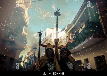 Sitges, Spagna. 23 Ago, 2014. I membri di "Ball de Diables' impostato su off i loro fuochi d'artificio come essi marzo a Sitges per la 'Correfocs' durante la "Festa Major' © Matthias Oesterle/ZUMA filo/ZUMAPRESS.com/Alamy Live News Foto Stock