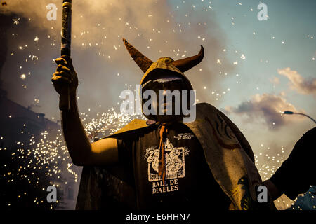 Sitges, Spagna. 23 Ago, 2014. Un membro di "Ball de Diables' mette fuori i suoi fuochi d'artificio al tramonto durante la " Festa Major de Sitges' © Matthias Oesterle/ZUMA filo/ZUMAPRESS.com/Alamy Live News Foto Stock