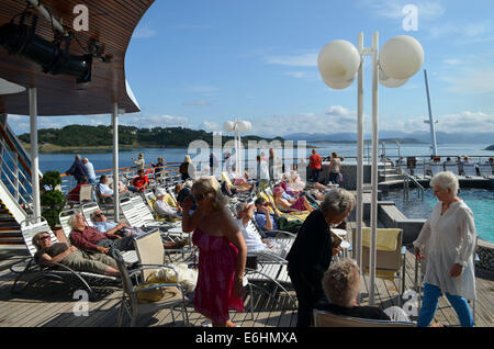 La barca continua lungo la costa norvegese, proseguendo costantemente verso sud, passando per le piccole isole. Mentre sul ponte le persone continuano Foto Stock