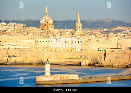 Golden mattina presto luce durante la nave da crociera di approccio alla Valletta con sole sul lungomare di edifici del Grand Harbour Foto Stock