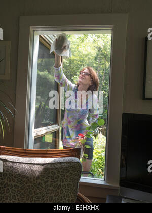 Donna finestra di lavaggio al di fuori di casa Foto Stock