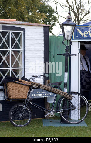 Replica 1940s tempo di guerra English shop con uno spazzacamino bicicletta appoggiata contro un lampione Foto Stock
