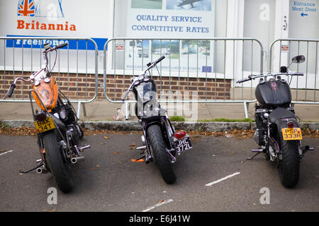Harley Davidson Moto parcheggiate al di fuori di negozi di high street a Brackley Foto Stock