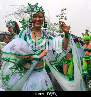 Londra, Regno Unito. Il 25 agosto, 2014. Una donna in verde e bianco danze custume sotto la pioggia al carnevale di Notting Hill Londra, Regno Unito. Credito: Mamusu rileva Kallon/Alamy Live News Foto Stock