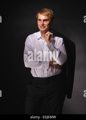 Casual e bello imprenditore moderno indossando abito nero e camicia bianca, studio shot sfondo scuro Foto Stock