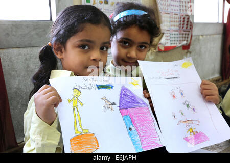 Due ragazze mostrare loro le immagini dipinte di scuola primaria del Cairo in Egitto Foto Stock