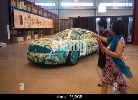 Pechino, Cina. 25 Ago, 2014. I visitatori osservano un dipinto di auto presso la base nazionale internazionale per scambi culturali (Pechino) a Pechino, capitale della Cina, e il agosto 25, 2014. La base nazionale internazionale per scambi culturali aperto qui il lunedì. Credito: Luo Xiaoguang/Xinhua/Alamy Live News Foto Stock