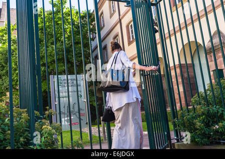 Giovane donna entrando ringhiera's gate Strasburgo Alsace Francia Europa Foto Stock