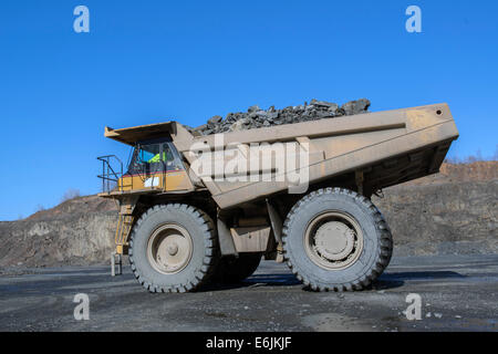 Branford, CT. 100 ton Caterpillar 7770D carrello alaggio trappola di basalto roccia minato dalla cresta di basalto presso l'impianto Tilcon. Foto Stock