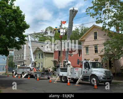 Elettricisti utilizzare cherry picker di autocarri per il lavoro di installare nuove linee elettriche in New Haven, CT. Foto Stock