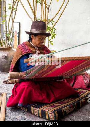 Il quechua donna indiana si intreccia con una fascetta telaio all'interno dell'Arte Precolombiana Museum - Cuzco, Perù Foto Stock