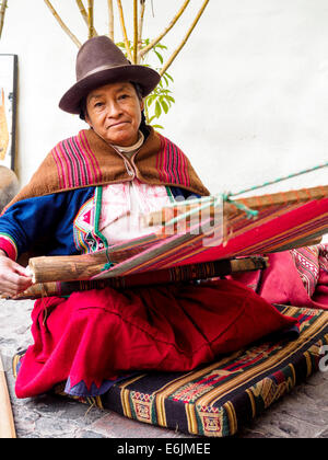 Il quechua donna indiana si intreccia con una fascetta telaio all'interno dell'Arte Precolombiana Museum - Cuzco, Perù Foto Stock