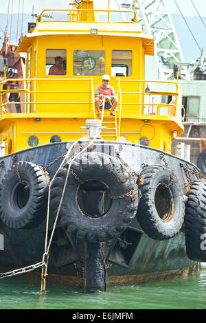 Marinaio cinese tenendo una fune su un rimorchiatore in Causeway Bay Typhoon Shelter, Hong Kong. Foto Stock