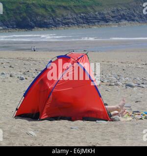 Una cornice rossa tenda per riparo dal vento sulla spiaggia di Porth Neigwl [Hell's bocca Bay ] Galles del Nord, Regno Unito Foto Stock