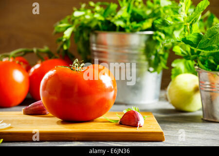 Pomodoro Fresco e verdure disposte su di un tavolo di legno Foto Stock