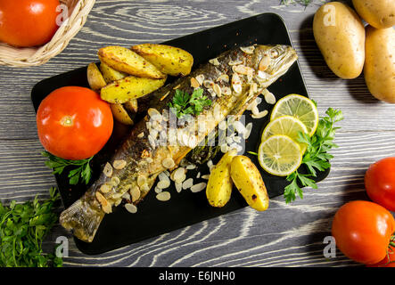 Trota fritta con mandorle, aneto e Spicchi di patate Foto Stock