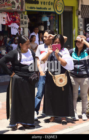 BANOS, ECUADOR - Marzo 2, 2014: persone non identificate in abiti tradizionali a guardare e scattare fotografie della sfilata di carnevale Foto Stock