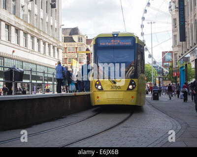 Una fermata del tram e gli acquirenti su Market Street nel centro della città di Manchester, Inghilterra Foto Stock