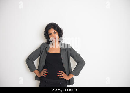 Indian business donna con grave aspetto e sfondo semplice Foto Stock