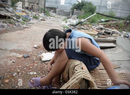 Agosto 25, 2014 - Cina Shanghai agosto 26: la ragazza di 14 anni Liu Jing che è venuto dalla contea a Yancheng Jiangsu Province della Cina in affitto casa in Shanghai con i suoi genitori durante le vacanze estive. I suoi genitori lavorano come raccoglitori di immondizia in un villaggio urbano di Shanghai e ogni estate e inverno vacanze avrebbero preso LIU Yan a Shanghai a partire dal loro paese natale. Per i 2 mesi a Shanghai, Liu ha appena di lasciare il villaggio urbano per lei ha paura del mondo esterno che è piena di cose che non ha mai sentito parlare di, inoltre, i suoi genitori andare al lavoro molto presto e torna a casa tardi e enon hanno tim Foto Stock