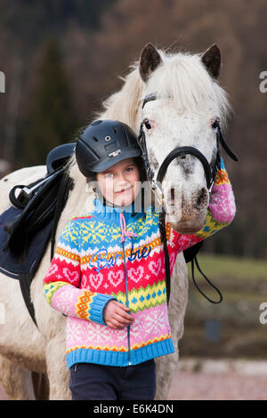 Ragazza in piedi accanto a un pony, grigio, Tirolo, Austria Foto Stock