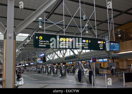 Volo i chioschi di check-in nell'area partenze internazionali della Vancouver Airport Terminal. Indicazioni per cancelli e trasporto Foto Stock