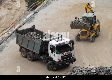 Vista aerea di escavatore rocce di caricamento su autocarro con cassone ribaltabile su un sito in costruzione Foto Stock