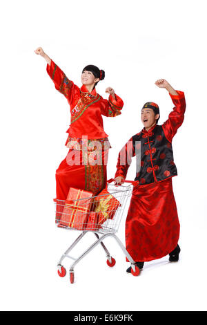 Coppia giovane vestito in abiti tradizionali shopping con carrello Foto Stock