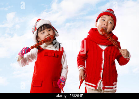 Un ragazzo e una ragazza eatting frutta candita Foto Stock