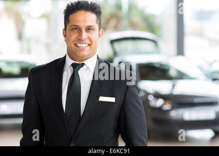 Felice giovani indiani venditore auto in showroom Foto Stock