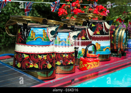 Canal arte popolare caraffe di metallo sul tetto di un narrowboat con union jack flag bunting sul Grand Union Canal Foto Stock