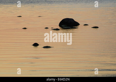 Rocce scure in luminose, calma e acqua colorata Foto Stock