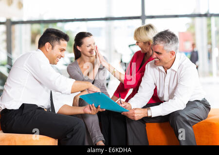 La famiglia felice di acquistare una nuova auto presso lo showroom del veicolo Foto Stock