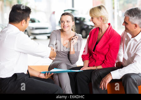 Venditore auto con handshake allegro giovane acquirente Foto Stock