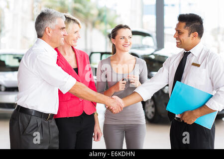 Felice uomo di mezza età handshake con venditore auto dopo l'acquisto di un auto Foto Stock