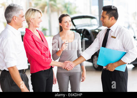 Allegro senior handshaking di donna con le vendite di automobili consulente presso la concessionaria Foto Stock