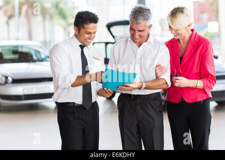 Coppia matura l'acquisto di una nuova auto presso lo showroom del veicolo Foto Stock