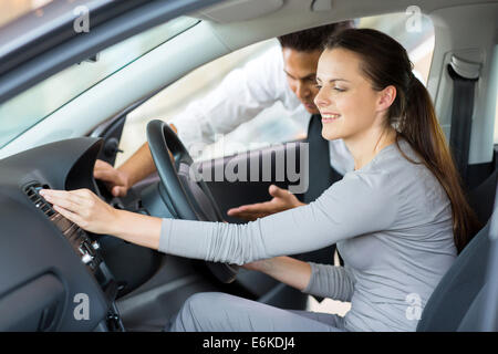 Auto consulente di vendita che mostra una nuova auto da una giovane donna Foto Stock