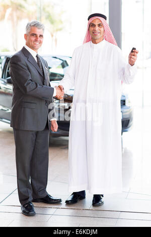 Felice senior venditore auto handshake con l'arabo il cliente Foto Stock