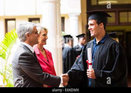 Padre orgoglioso congratularmi con suo figlio sul giorno di graduazione Foto Stock