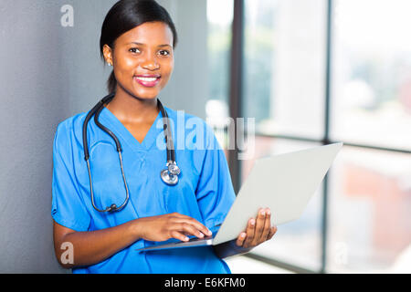 Carino sanità africana lavoratore utilizzando laptop al lavoro Foto Stock