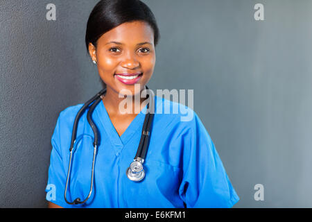 Piuttosto giovani African Medical intern in piedi contro il muro Foto Stock