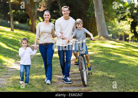 Felice famiglia giovane trascorrere del tempo di qualità insieme nel parco Foto Stock