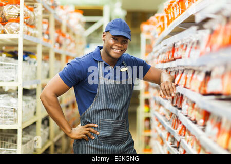 Sorridente hardware africana store permanente dei lavoratori mediante gli elementi di fissaggio corsia Foto Stock