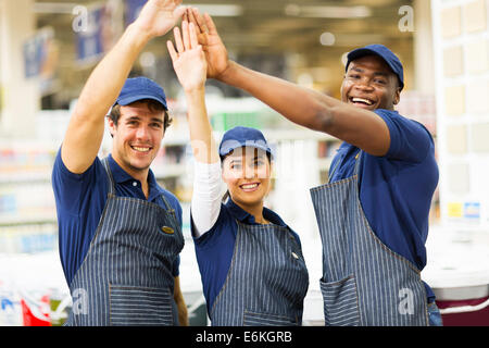 Il gruppo di allegro negozio di ferramenta di lavoratori ad alta cinque Foto Stock