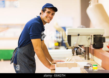 Bello il carpentiere in piedi in officina Foto Stock